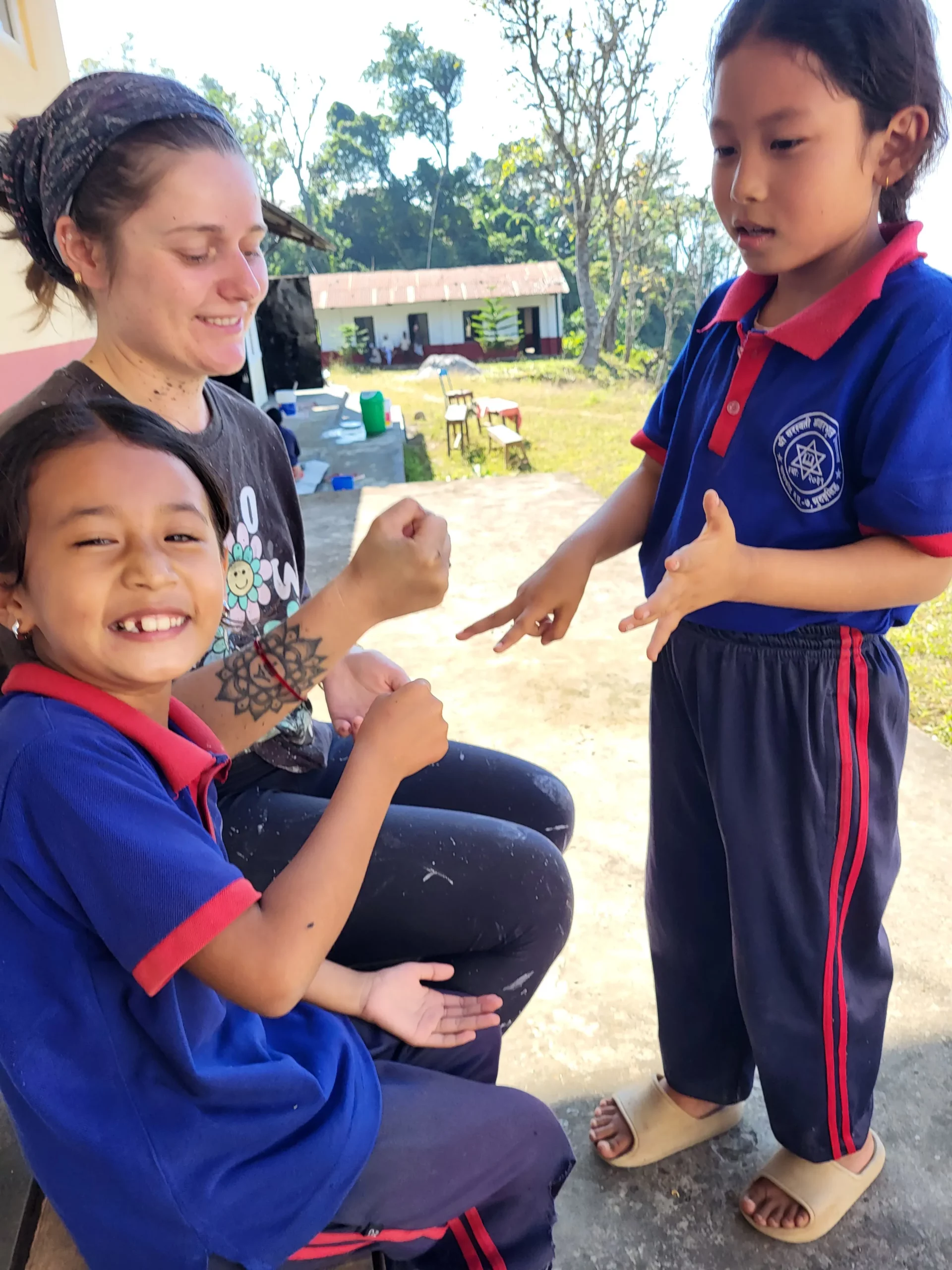 Mathilde joue avec deux élèves dans la cour.
