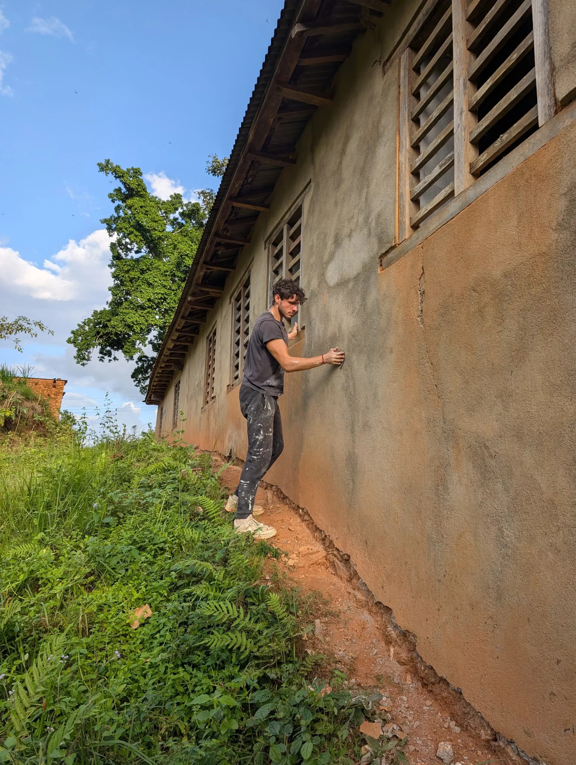 Bénévole ponçant le mur extérieur