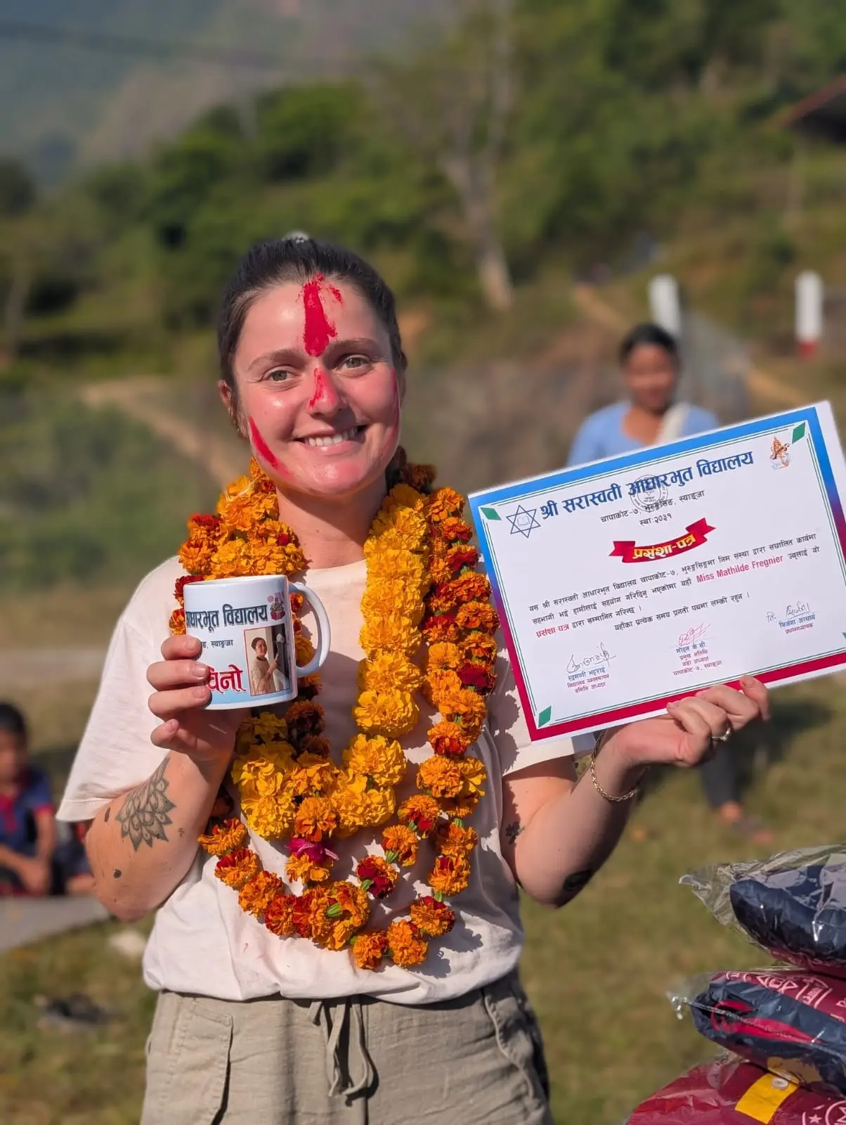 Mathilde reçoit un diplôme et une tasse en remerciement.