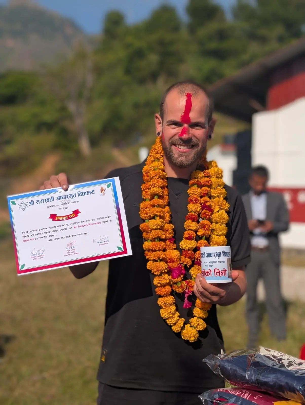 François reçoit un diplôme et une tasse en remerciement.