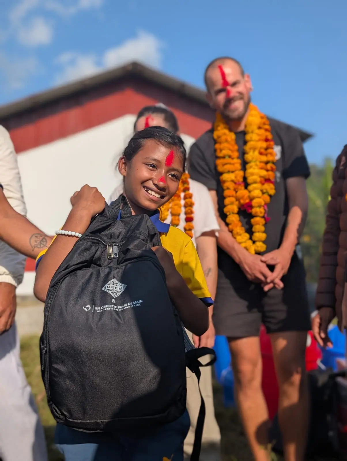 Jeune élève qui sourit avec son nouveau sac sur l’épaule.