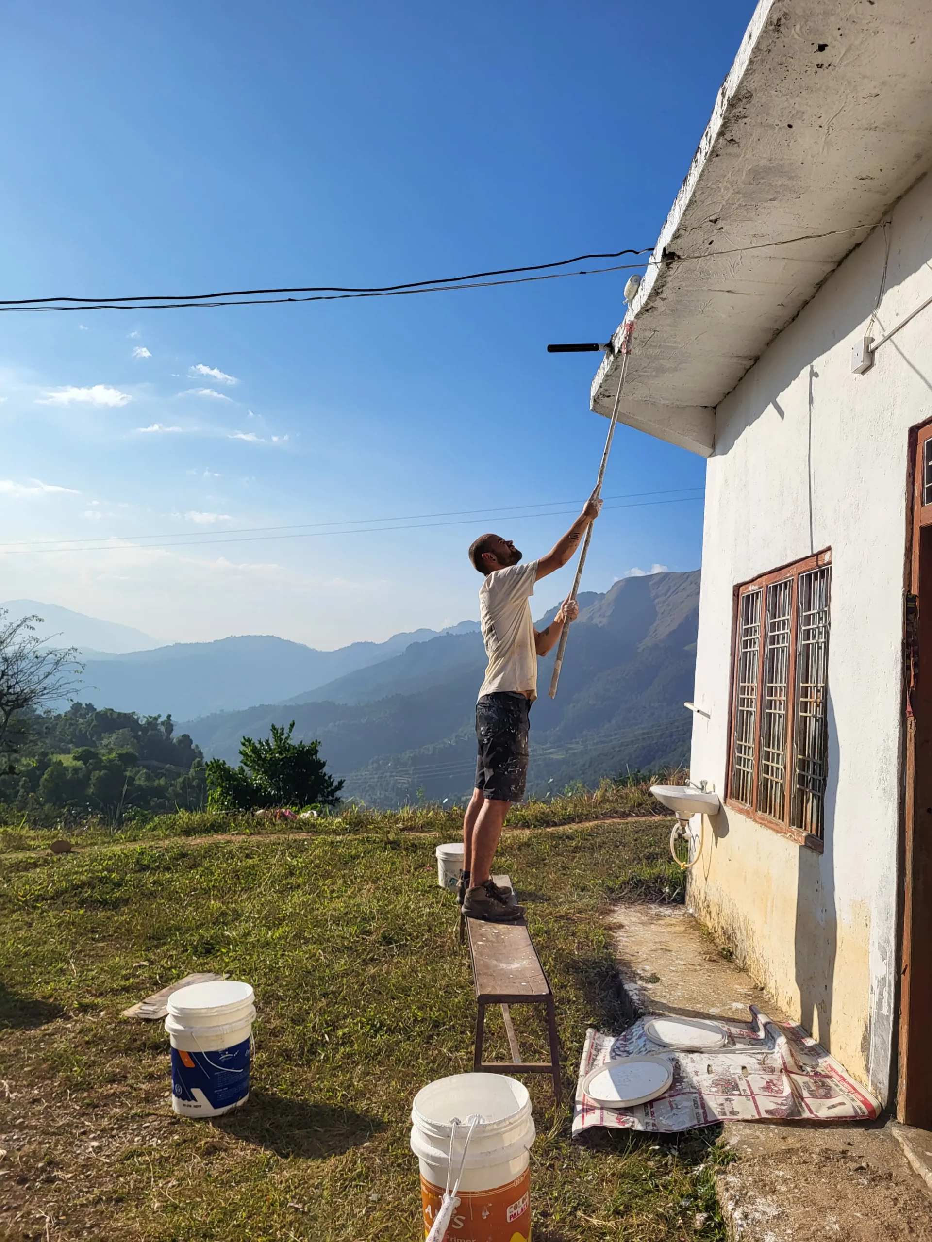 Vue sur l’école et la cour sécurisée par un grillage.